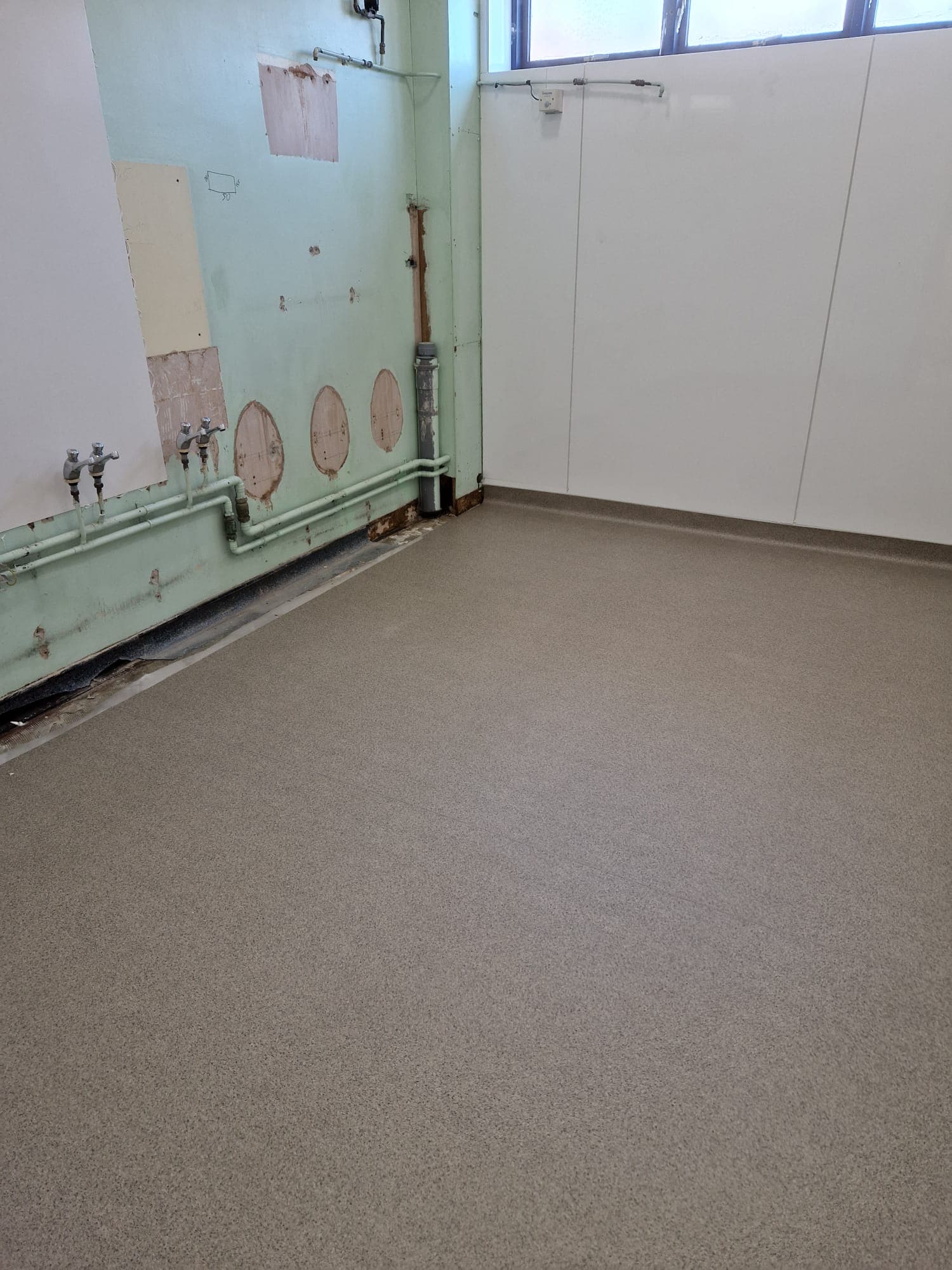 Self-smoothing resin pour edge-to-edge in a back-of-house space